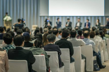Sahnede, iş ve eğitim yatırım kavramı hakkında hoparlörlere sahip konferans salonu veya seminer toplantı seyirci görünümünde arka