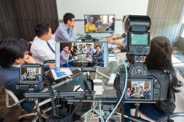 Набор камер со смартфоном и экшн-камерой на штативе над группой компаний, проводящих видеоконференцию со своим менеджером, Live Streaming for enterprise concept