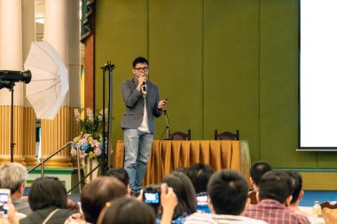 Konferans salonu veya Seminer Toplantı, iş ve eğitim kavramı sunusu ekran üzerinden sahnede rahat takım elbise ile Asya hoparlör closeup portresi