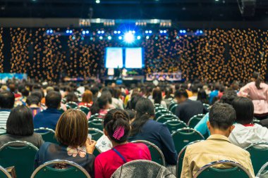 Sahnede, iş ve eğitim yatırım kavramı hakkında hoparlörlere sahip konferans salonu veya seminer toplantı seyirci görünümünde arka