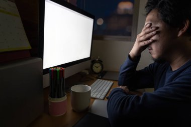 Asya oturan ve geç ciddi eylem, çalışma sert ve çok geç kavramı ile iş yerinde bilgisayar masaüstü önü tablo çalışkan işadamı portresi