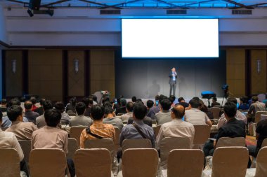 Arka tarafında oturan ve düşük ışık konferans salonu, olay ve seminer kavramı sahnede speackers dinleme kitlelere