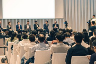 Sahnede, iş ve eğitim yatırım kavramı hakkında hoparlörlere sahip konferans salonu veya seminer toplantı seyirci görünümünde arka