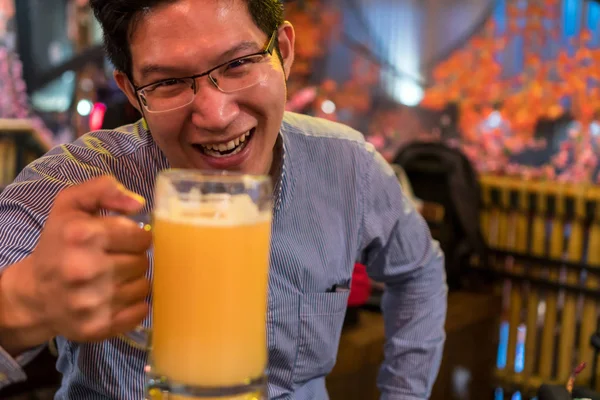 Asian businessman in happiness action and drinking beer after work or success job in pub and restaurant, relax and drink concept