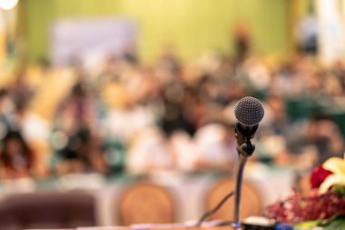 Mikrofon üzerinden soyut fotoğraf seyirci arka plan, eğitim ve öğrenme kavramı ile konferans salonu veya seminer odası bulanık