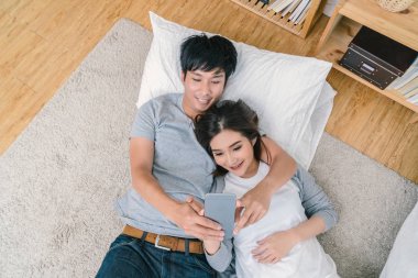 Mutlu Asya halı yatak, Çift selfie kavramı ile katta selfie için teknoloji akıllı telefon kullanarak aşık üstten görünüm,