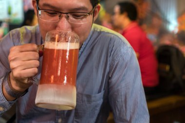 Mutlu eylem Asyalı işadamı ve pub ve restoranda iş veya başarı iş sonra bira içme, dinlenmek ve içki kavramı