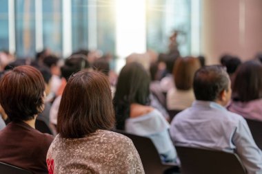 Seyirci arkadan görünüş hoparlörlere sahip konferans salonu veya seminer toplantıyla beyin fırtınası ve sahne, iş ve eğitim yatırım kavramı hakkında konuşmak vardır
