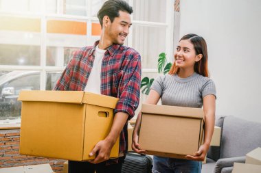 Yeni ev içinde hareket etmek için büyük karton kutu taşıyan Asya Genç Çift hareketli ve ev kavramı avcılık