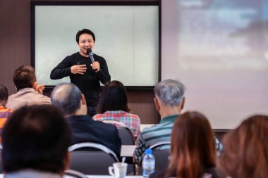 Asya hoparlör veya oda konferans salonu veya Seminer Toplantı odası, iş ve eğitim kavramı içinde belgili tanımlık perde ile sunulması önünde sahnede rahat takım elbise ile ders