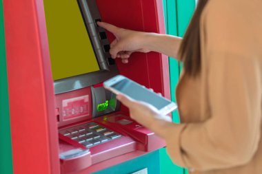 Atm önünde iş otomatik vezne makinesi kavramı geri çekilmesi için akıllı cep telefonu kullanan kadın