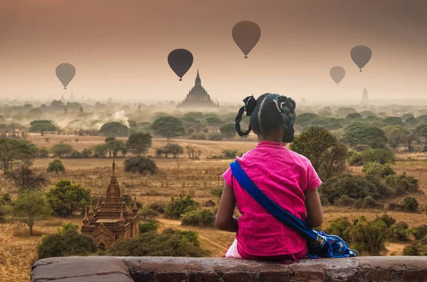 Birman yüzünde Bagan antik tapınaklar gökyüzü üzerinde sıcak hava ile gündoğumu zaman, Myanmar bakarak geleneksel thanaka kızla arka yüzü