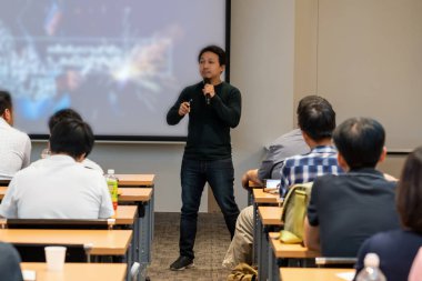 İş veya eğitim semineri, iş ve eğitim kavramı sunusu ekran üzerinde düşük ışık ile Oda önünde sahnede rahat takım elbise ile Asya hoparlör