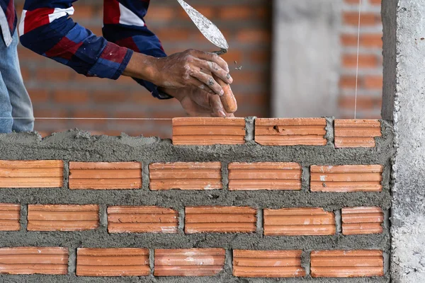 Yeni sanayi sitesi tuğla döşeme Closeup el profesyonel inşaat işçisi. Sanayi ve duvar kavramı oluşturmak