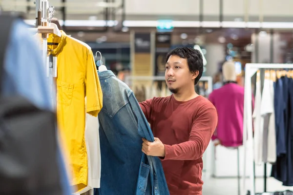 在购物中心的服装店 有胡须的聪明亚洲男人选择衣服 比较衬衫 风格和消费理念的区别 — 图库照片