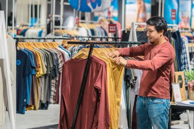 Giyim Mağazası, Alışveriş Merkezi, giysiler seçmek sakallı akıllı Asya adam renkli t-sshirts, moda ve tüketim kavramı arıyorsunuz.