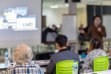 Sahne Alanı'ndaki konferans salonu veya Seminer Toplantı, iş ve eğitim kavramı hoparlör dinleme seyirci arkadan görünüş