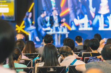 Konferans salonu veya Seminer Toplantı, iş ve eğitim yatırım kavramı hakkında sahnede hoparlörler dinleme seyirci arkadan görünüş