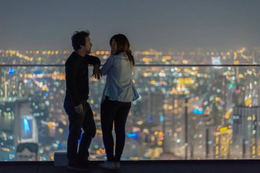 Romantik Çift şehir manzarası arka plan, Lover ve calentine tatil konsepti, düşük ışık bulanık fotoğraf üzerinde gece bangkok modern binadan çatı da ayakta