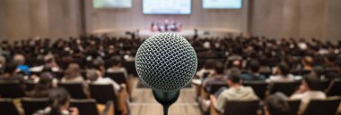 Banner and web page or cover template of Microphone over the Abstract blurred photo of conference hall or seminar room with attendee background, Business meeting concept clipart