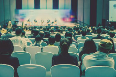 Konferans salonu veya Seminer Toplantı, iş ve eğitim yatırım kavramı hakkında sahnede hoparlörler dinleme seyirci arkadan görünüş