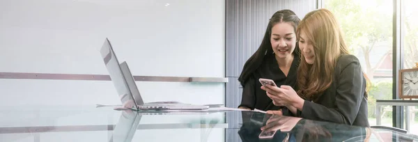 バナーとウェブページまたは現代の職場でノートパソコンと技術のスマートフォンを座って使用して2人のアジアの若いビジネスマンのテンプレートをカバー ビジネスライフスタイルと技術の概念 — ストック写真