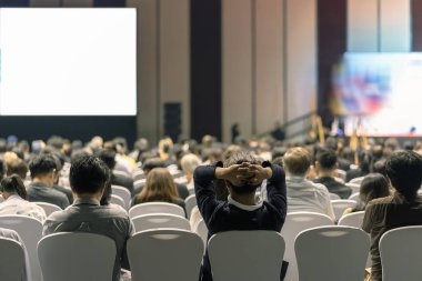 Konferans salonu veya Seminer Toplantı, iş ve eğitim yatırım kavramı hakkında sahnede hoparlörler dinleme seyirci arkadan görünüş