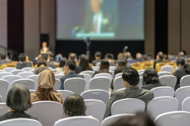 Konferans salonu veya Seminer Toplantı, iş ve eğitim yatırım kavramı hakkında sahnede hoparlörler dinleme seyirci arkadan görünüş
