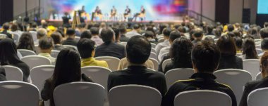 Afiş kapak sayfasından konferans salonu veya Seminer Toplantı, iş ve eğitim yatırım kavramı hakkında sahnede hoparlörler dinleme seyirci arkadan görünüş