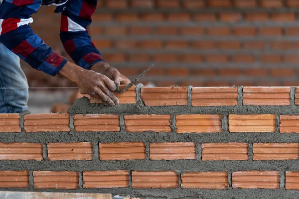 Closeup hand professional construction worker laying bricks in new industrial site. construct industry and masonry concept