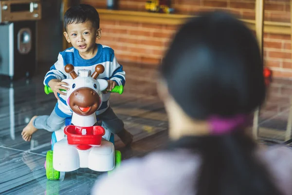 Backside of Asian single mom with son are playing with toy together when living in loft house for Self learning or home school, Family and single mom concept, selective focus