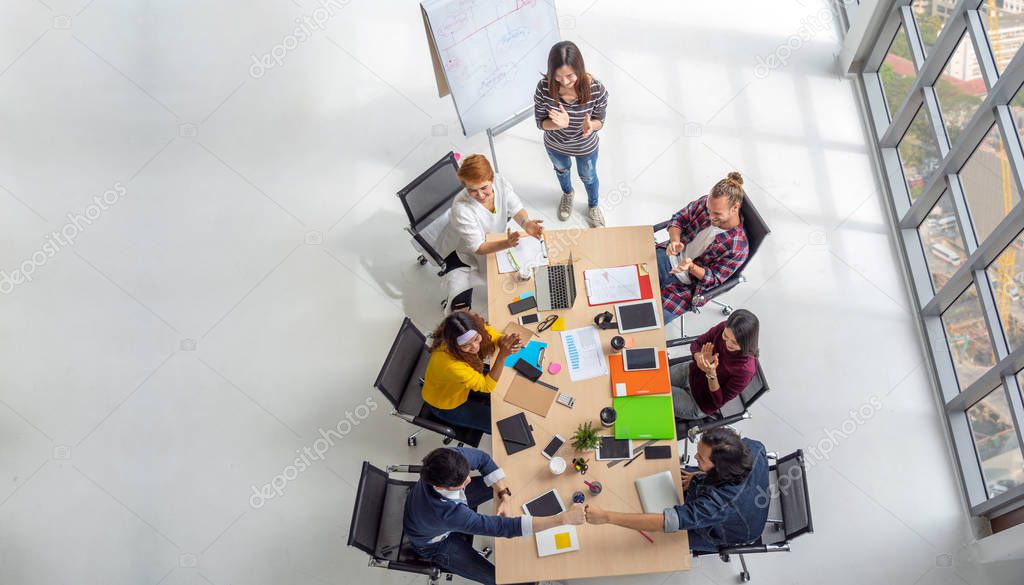 Top view scene of Asian and Multiethnic Business people with casual suit sitting and Fist Bumping Corporate Colleagues Teamwork with happy action in the modern workplace, people business group concept