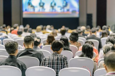 Konferans salonu veya Seminer Toplantı, iş ve eğitim yatırım kavramı hakkında sahnede hoparlörler dinleme seyirci arkadan görünüş