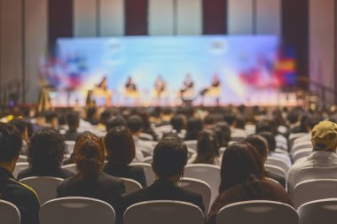 Konferans salonu veya Seminer Toplantı, iş ve eğitim yatırım kavramı hakkında sahnede hoparlörler dinleme seyirci arkadan görünüş