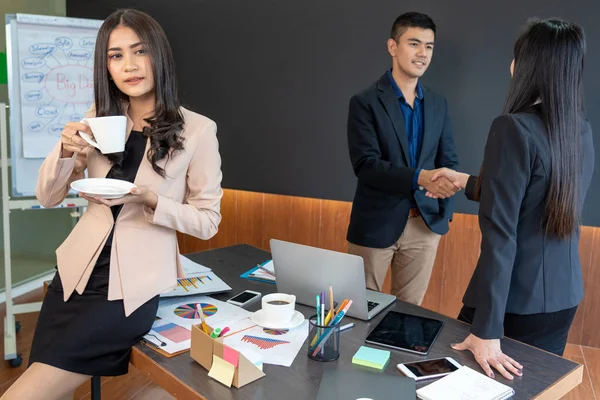 アジアのビジネスウーマンは モデレン オフス ピープル ビジネス グループ リレーションシップ コンセプトの裏側に立って握手しているワークメイトを無視して立っている — ストック写真