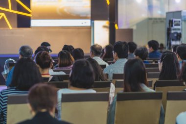 Konferans salonu veya Seminer Toplantı, iş ve eğitim yatırım kavramı hakkında sahnede hoparlörler dinleme seyirci arkadan görünüş