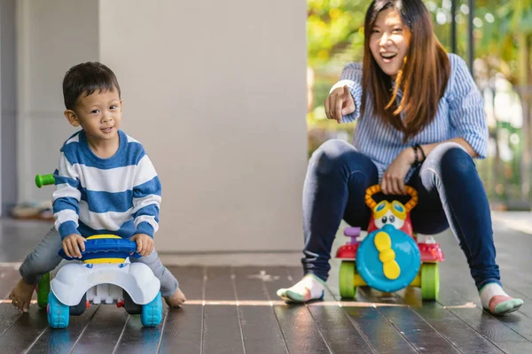 Asian single mom with son are playing with car toy together when living in modern house for Self learning or home school, Family and single mom concept, selective focus