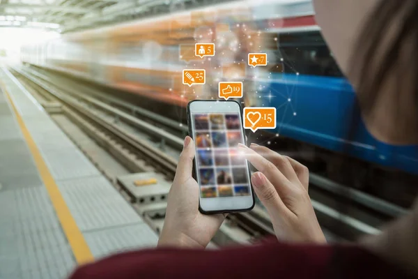 特写镜头的妇女使用智能手机的社交网络媒体与数量的喜欢 人和黄光石图标在轻轨铁路或地铁在城市旅行 社会网络概念 — 图库照片