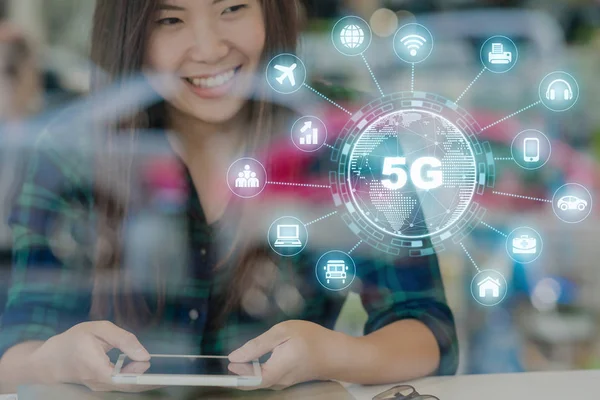 5G technology with various icon internet of thing over hand using the smart mobile phone on the desk beside the glass in workplace or co-working space or modern office, IOT and Connectivity concept