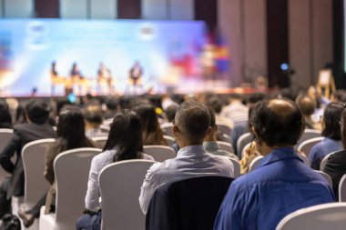 Konferans salonu veya Seminer Toplantı, iş ve eğitim yatırım kavramı hakkında sahnede hoparlörler dinleme seyirci arkadan görünüş