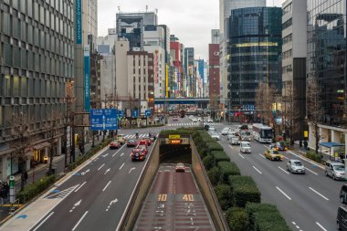 Tokyo, Japonya - Şubat 2019 : 15 Şubat 2019'da Tokyo'da Shimbashi ve Ginza bölgesinde çapraz yürüyüş yoluyla üstgeçit kavşağında yürüyen birçok araba ve kalabalık tanımsız kişinin yoğun saat trafiği