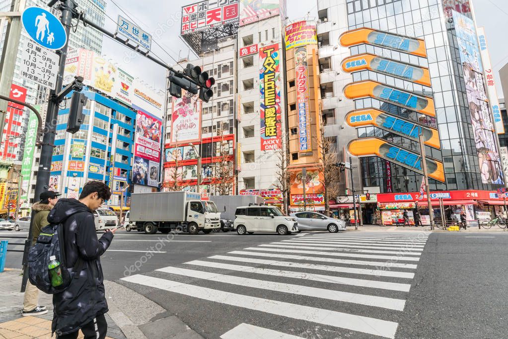 TOKYO, JAPAN - FEB 2019 : Undefined People and car Crowd with aerial view pedestrains intersection cross-walk Shibuya crosswalk car traffic at afternoon time on Febuary 14, 2019 in Tokyo, Japan.