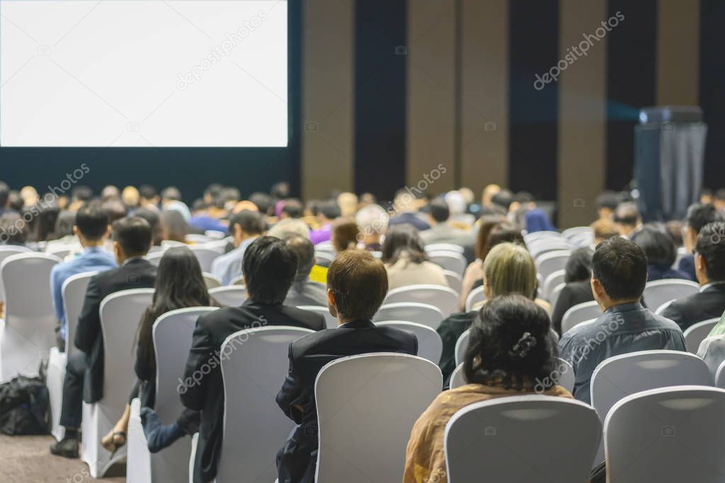 Rear view of Audience listening Speakers on the stage in the conference hall or seminar meeting, business and education about investment concept