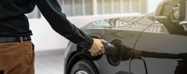 Banner Closeup asya Teknisyen el bakım için servis merkezinde elektrikli araba veya Ev şarj ediyor, Çevre dostu alternatif enerji konsepti, kapak ve afiş