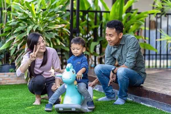 Asian family with son are playing with toy together when living in Front lawn of modern house for Self learning or home school, Family and single mom concept, selective focus