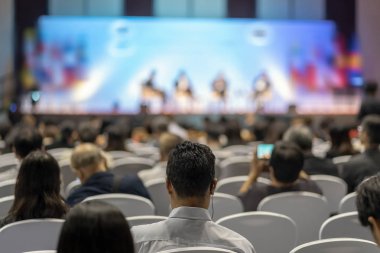 Konferans salonu veya Seminer Toplantı, iş ve eğitim yatırım kavramı hakkında sahnede hoparlörler dinleme seyirci arkadan görünüş