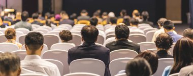 Afiş kapak sayfasından konferans salonu veya Seminer Toplantı, iş ve eğitim yatırım kavramı hakkında sahnede hoparlörler dinleme seyirci arkadan görünüş