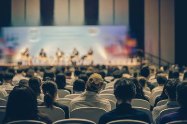 Konferans salonu veya Seminer Toplantı, iş ve eğitim yatırım kavramı hakkında sahnede hoparlörler dinleme seyirci arkadan görünüş