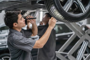 Asya mekanik kontrol ve müşteri konsepti için showroom, teknisyen veya profesyonel çalışmanın bir parçası olan bakım servis merkezinde lastik meşale