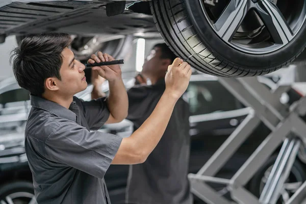 Azjatycki Mechanik Sprawdzanie Latarka Opony Centrum Serwisowym Który Jest Częścią — Zdjęcie stockowe